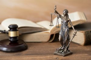 Themis statue,books and gavel on wooden table