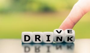 Drink or drive? Hand turns dice and changes the word "drink" to "drive", or vice versa.