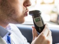 Man Sitting Inside Car Taking Alcohol Test, using tech to help you stay safe on the road