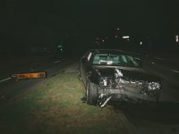 a wrecked car left in the road at night